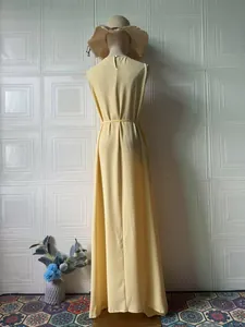 Back view of a sleeveless yellow maxi dress with waist tie and flowy skirt