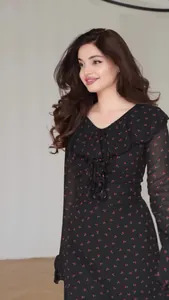 Detail of black chiffon floral dress featuring delicate V-neck and ruffle sleeves