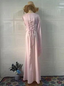 Back view of an elegant pink satin maxi dress featuring a corset lace-up waist detail