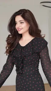 Detail view of a black chiffon V-neck dress with red cherry print and elegant ruffles
