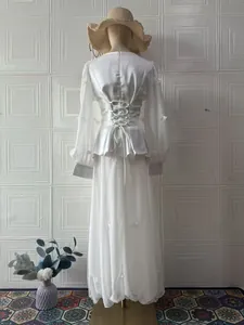 Detailed back view of an elegant white long-sleeved dress set with lace-up waist design