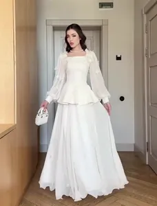 Elegant white long-sleeved two-piece dress set with flowing skirt for women