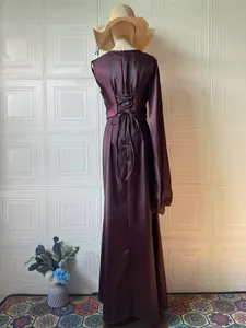 Back view of elegant purple long-sleeve silky dress with lace-up corset detail