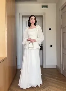 Elegant white long-sleeved vintage dress set worn by a model in a luxury interior