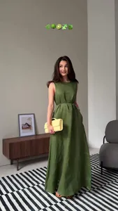 Elegant sleeveless olive green linen maxi dress styled in a modern minimalist interior