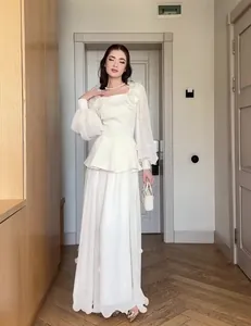 Elegant white two-piece maxi dress set featuring lantern sleeves and peplum top