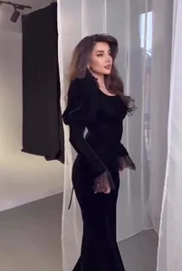 Side view of elegant black palace-style velvet dress with lace cuffs and puff sleeves.