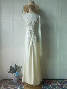 Back view of ivory long-sleeved dress showing elegant lace-up detailing on the waist