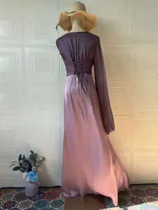 Back view of an elegant purple long-sleeve maxi dress with corset lace-up detail.