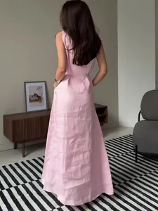 Sleeveless pink maxi dress with pockets shown in a modern indoor lifestyle setting