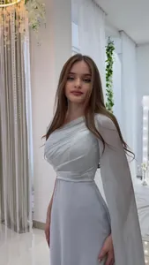 Detailed view of an elegant light blue one-shoulder dress with sophisticated draping