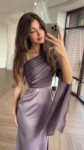 Detailed view of elegant purple satin dress with unique one-shoulder pleated design
