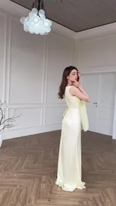 Elegant pale yellow silky long dress with a corset back detail in a luxury interior.