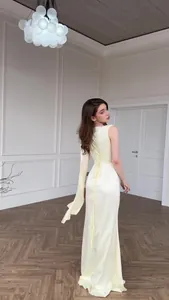 Elegant pale yellow satin evening gown with a backless corset lace-up detail view