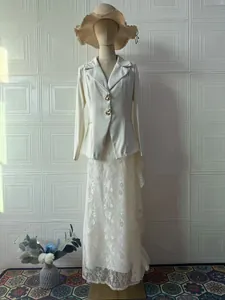 Elegante tweedelige set met witte blazer met lange mouwen en lange rok van bloemenkant