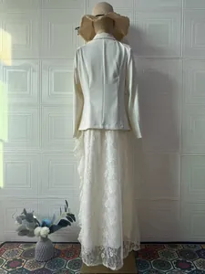 Achteraanzicht van een elegante witte blazer en lange kanten rok als een set.