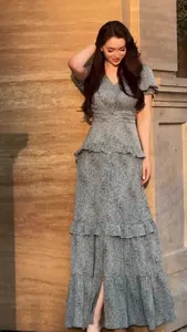 Elegant vintage floral tiered long dress with puff sleeves shown in warm sunset light
