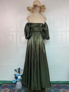 Back view of an elegant olive green satin evening gown featuring corset lacing details