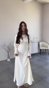 Elegantes weißes langärmliges Satinkleid in einer minimalistischen Innenraumumgebung