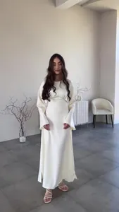 Elegantes cremefarbenes Langarm-Maxikleid mit weiten Manschetten in minimalistischem Studio