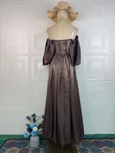 Back view of brown off-shoulder satin gown featuring puffy sleeves and lace-up detail