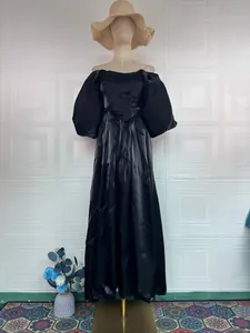 Detailed view of elegant black satin off-the-shoulder gown with dramatic puff sleeves