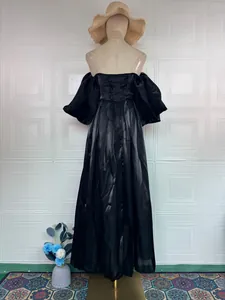 Back view of an elegant black satin off-the-shoulder gown with lace-up detail and puff sleeves.