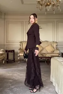 Elegante bruine blazer met lange mouwen en maxi-rok van kant in luxe kamer.