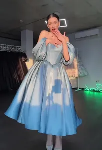Elegant light blue off-the-shoulder ball gown with voluminous puff sleeves for parties.