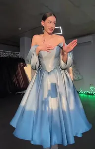 Detail of an elegant off-the-shoulder light blue satin ball gown with puff sleeves