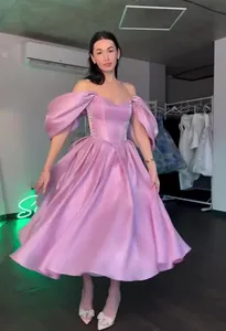 Elegant pink satin off-shoulder evening gown with dramatic puff sleeves and ball skirt