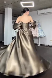 Back view of elegant bronze metallic off-the-shoulder formal gown with corset buttons