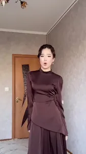 Elegante vestido de satén marrón de manga larga con cintura alta ajustada en una modelo