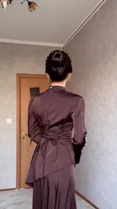 Vista posterior de un vestido de satén marrón de manga larga con lazos en cintura