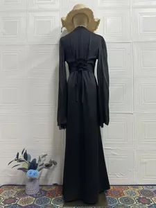 Rückendetail eines eleganten schwarzen langärmeligen Maxikleides mit Schnürung an der Taille