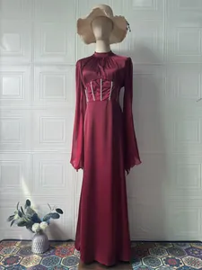 Elegantes weinrotes Langarm-Maxikleid mit Korsett-Taillendetail auf einer Schaufensterpuppe