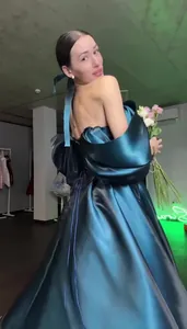Back view of elegant dark teal satin off-shoulder princess gown with lace-up detail