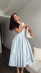 Elegant light blue sleeveless V-neck maxi dress with a pleated skirt worn by model