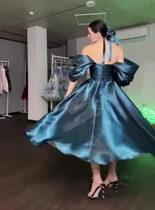 Back view of elegant teal satin princess evening gown with flowing skirt and puffed sleeves