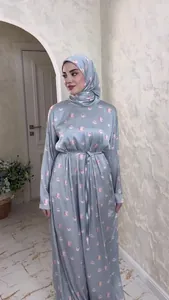 Detailed view of elegant light blue satin long-sleeved dress with pink floral print.