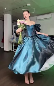 Elegant off-the-shoulder teal satin evening gown with voluminous puffy sleeves and full skirt