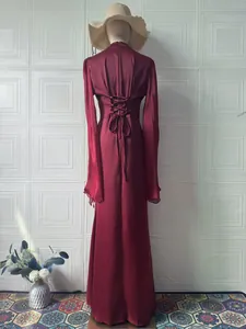 Detail eines weinroten Maxikleides mit elegantem Rückenschnürung und langen Ärmeln