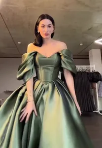 Elegant olive green off-the-shoulder satin ball gown featuring a voluminous pleated skirt