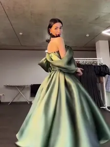 Detailed back view of a luxurious sage green satin evening gown with elegant puffed sleeves.