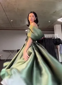 Elegant olive green satin princess gown with off-the-shoulder sleeves for formal events.