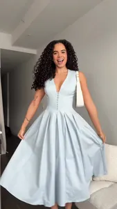 Elegant light blue V-neck sleeveless midi dress with a pleated skirt worn by a model.