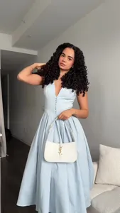 Detail view of an elegant light blue V-neck sleeveless long dress worn by a model