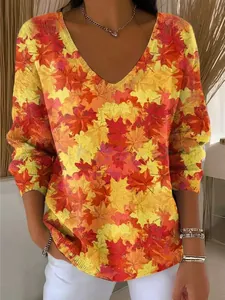 Detailweergave van dames top met V-hals en levendige esdoornbladprint in rood