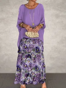 Full length view of a purple top and floral skirt set worn by a model on a grey background