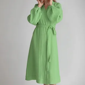 Close-up detail of a light green gauze wrap dress with smocked elasticated cuffs.